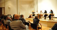 Diskussionsteilnehmer*innen sitzend am Holztisch auf dem Podium, Quelle: DTF