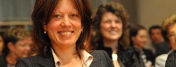 Sibylle Thylen sitzend mit ihrem Rommel-preis und einer roten Mappe