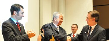 Cem Özdemir, Mehmet Varlik und Kerim Arpad stehen um älteren Preisträger klatschend herum