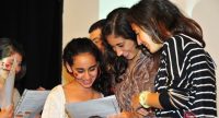 junge Frauen schauen lachend auf ein Blatt in Klarsichtfolie, Quelle: DTF
