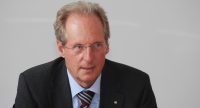 Mann im schwarzen Sakko schaut nach vorne, Quelle: DTF