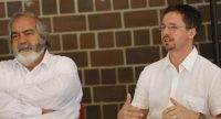 zwei Männer in weißen Hemden sitzen nebeneinander, Kerim Arpad spricht gestikulierend, Quelle: DTF