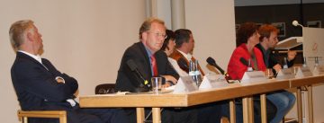 OB-Kandidat*innen sitzen an einem langen Holztisch