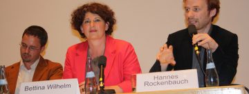 OB-Kandidat*innen sitzen an einem langen Holztisch