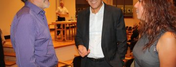 zwei Männer und eine Frau stehen zusammen und lächeln