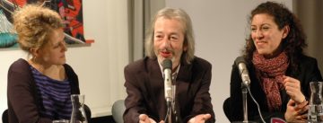 Mann und zwei Frauen im Gespräch vor Banner des DTF