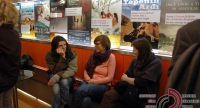 junge Frauen sitzen lehnend an einer Wand mit Kinopostern, Quelle: DTF
