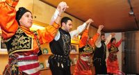 Männer und Frauen in traditioneller Kleidung tanzen, Quelle: DTF