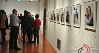 Menschenmenge vor Wand mit ausgestellten Fotos in einem Ausstellungsraum, Quelle: DTF