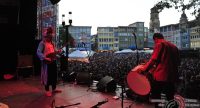 Trommler und Mann mit Saiteninstrument auf rot beleuchteter Bühne, Quelle: DTF