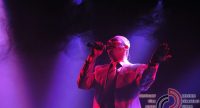 Mann im weißen Anzug singt auf violett beleuchteter Bühne, Quelle: DTF