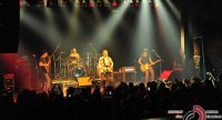 Band auf rot erleuchteter Bühne vor Silhouette des Publikums, Quelle: DTF