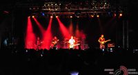 Band auf rot beleuchteter Bühne vor Silhouette des Publikums, Quelle: DTF