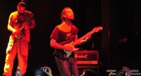 Gitarrist und Saxophonist auf rot beleuchteter Bühne vor Silhouette des Publikums, Quelle: DTF