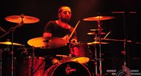 Schlagzeuger sitzend auf rot beleuchteter Bühne, Quelle: DTF