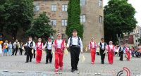 Mädchen und Jungs in traditioneller Kleidung in einer Pfeil-Aufstellung tanzend, Quelle: DTF