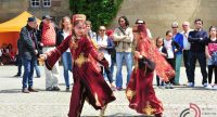 Mädchen und Jungs in traditioneller Kleidung tanzen miteinander, Quelle: DTF