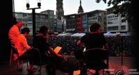 Band auf rot beleuchteter Bühne mit Suttgarter Stadt im Hintergrund, Quelle: DTF