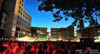 rot beleuchtetes Publikum und Stadt im Hintergrund, dunkler Nachthimmel, Quelle: DTF