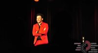 Mann im roten Anzug spricht gestikulierend auf der Bühne, Quelle: DTF