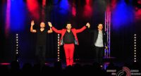 vier Männer tanzend auf der Bühne mit erhobenen Armen vor Silhouette des Publikums, Quelle: DTF