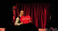 ältere Frau hält lächelnd ein rotes Herzförmiges Kissen mit dem Namen Fatma in die Luft, Quelle: DTF