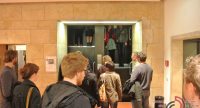 Menschen stehen in Kleingrüppchen rund um einen Paternoster-Aufzug, Quelle: DTF