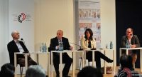 Diskussionsteilnehmer sitzend auf dem Podium vor Silhouette des Publikums, Quelle: DTF