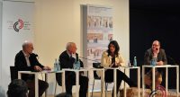 Diskussionsteilnehmer sitzend auf dem Podium vor Silhouette des Publikums, Quelle: DTF