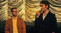 zwei Männer sprechen vor goldenem Vorhang, Quelle: DTF