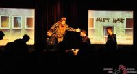 Frau in Anzug mit Leopardprint steht auf der Bühne vor SIlhouette des Publikums, Quelle: DTF