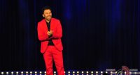Mann im roten Anzug vor SIlhouette des Publikums, Quelle: DTF