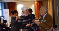 älterer Herr im braunen Sakko spricht lachend mit einer lächelnden Frau mit Kopftuch, Quelle: DTF