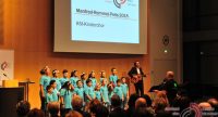 singender Kinderchor auf der Bühne vor Publikum, Quelle: DTF