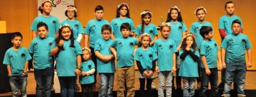 Kinderchor in blauen SHirts vor der Bühne