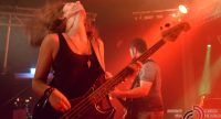 Bassistin mit nach hinten geneigtem Kopf auf rot beleuchteter Bühne, Quelle: DTF