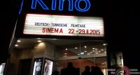 Eingang des Kinos mit Schild zur Werbung der Sinema Tage vor dunklem Abendhimmel im Hintergrund, Quelle: DTF