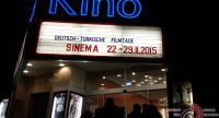 Eingang des Kinos mit Schild zur Werbung der Sinema Tage vor dunklem Abendhimmel im Hintergrund, Quelle: DTF