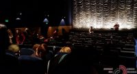 dunkler Kinosaal mit Menschen, die ihren Platz suchen, Quelle: DTF