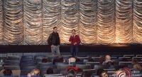 zwei Männer unterhalten sich vor goldenem Vorhang vor der ersten Reihe, Quelle: DTF