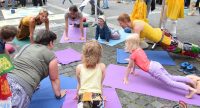 Erwachsene und Kinder auf Yoga-Matten in einem Kreis, Quelle: DTF