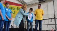 Kinder und Erwachsene auf der Bühne vor Bannern des DTF, Quelle: DTF