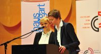 zwei Frauen an Rednerpult neben Banner des Literaturhauses Stuttgart und Banner des DTF, Quelle: DTF