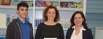 Frau mit Buch in den Händen neben jungem Mann in weißem Hemd und DTF Mitarbeitern im Sakko