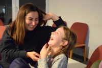 Frau und Mädchen sitzen lachend nebeneinander, Quelle: DTF