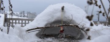 kleine Hütte aus Schnee, drinnen eine Papierfigur