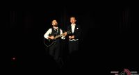 zwei Männer in Anzügen, sie sehen wie Magier aus, der eine spielt Gitarre, Quelle: DTF