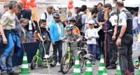 Kinder und Polizei mit Fahrrädern vor einem Hindernislauf mit grünen Hütchen, Quelle: DTF