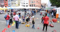 Kinder und Erwachsene rumwuselnd auf dem Marktplatz, Quelle: DTF