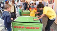 Kinder und Erwachsene spielen Tisch Kicker in einem Zelt, Quelle: DTF